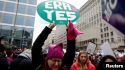 FILE - A demonstrator holds a sign calling for an equal rights amendment (ERA) during in the Third Annual Women's March at Freedom Plaza in Washington, Jan. 19, 2019. 