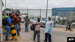 FILE - A nurse working for the National Health Department escorts a traveler to get a COVID-19 test done before entering South Africa at the Beitbridge border post between South Africa and Zimbabwe, near Musina, South Africa, Jan. 8, 2021. 