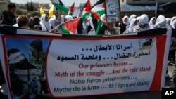 People hold banners during a rally in support of Palestinian prisoners in the West bank City of Bethlehem, April 17, 2017. 