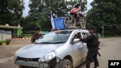 This photo taken on July 2, 2024 shows members of the ethnic armed group Ta'ang National Liberation Army (TNLA) inspecting a car at a checkpoint in the town of Kyaukme in Myanmar's northern Shan State.