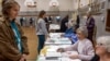 FILE - Election workers assist voters at Maryland Avenue Montessori School during Wisconsin's Supreme Court election in Milwaukee, April 4, 2023. 