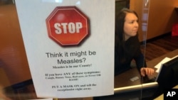 Un signe prévient les patients des symptômes de la rougeole dans un cabinet de pédiatre à Scottsdale, Arizona, le 7 février 2015. 