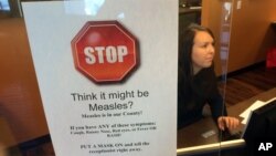 FILE - A sign warns of the dangers of measles in the reception area of a pediatrician's office in Scottsdale, Arizona, Saturday, Feb. 7, 2015. 