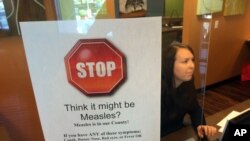 FILE - A sign warns of the dangers of measles in the reception area of a pediatrician's office in Scottsdale, Arizona, Feb. 7, 2015. 