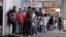 People line up before filling out applications while looking for job opportunities, in front of the building of an employment agency in Brasilia, Brazil, March 8, 2016.