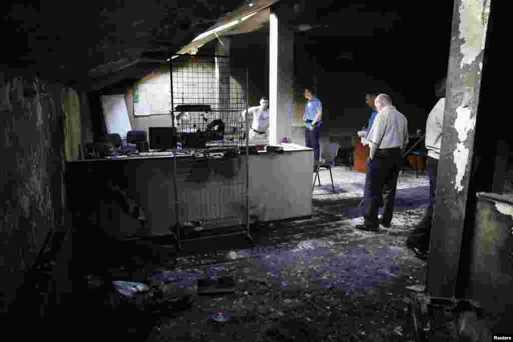 Interior Ministry security force members and investigators work inside a burned out regional office of the All-Ukrainian Union &quot;Svoboda&quot; (Freedom) Party, led by Oleh Tyahnybok, in Odessa, May 28, 2014.
