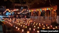 ປະຊາຊົນໄຕ້ໂຄມໄຟຢູ່ວັດແຫ່ງນຶ່ງໃນນະຄອນຫຼວງວຽງຈັນ.