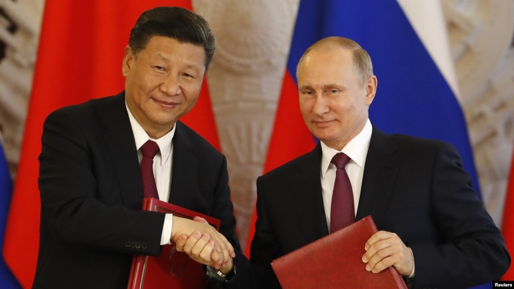 资料照：俄罗斯总统普京与中国领导人习近平在克里姆林宫参加一个签字仪式后握手。（2017年7月4日）(photo:VOA)