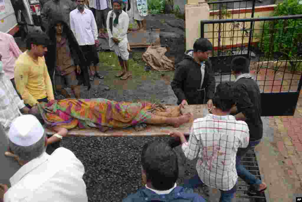 The body of a landslide victim is carried to a hospital in Ghodegaon village in the western Indian state of Maharashtra, Wednesday, July 30, 2014.