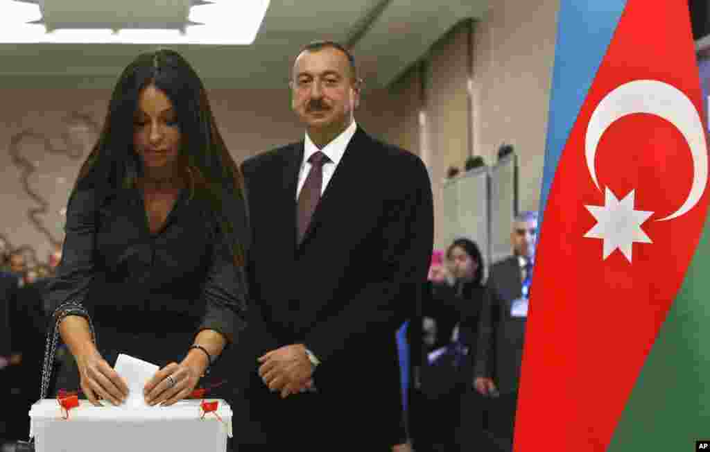 Azerbaijan President Ilham Aliyev looks on as his wife Mehriban casts her vote at a polling station in Baku, Oct. 9, 2013.