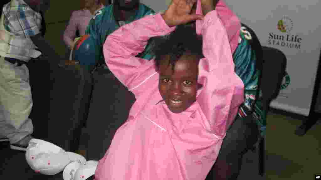 Quake survivor Nathana Gerome puts on gift from Dolphins