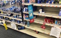 马里兰州蒙哥马利郡一家商店在货架贴出的口罩、手套、洗手液等物品无货的通知。(2020年3月8日)