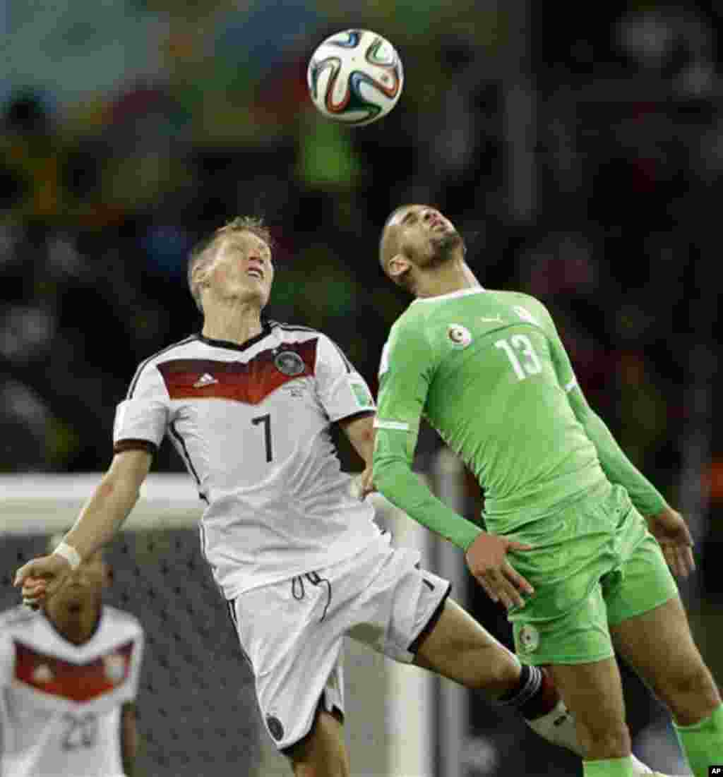 Germany's Bastian Schweinsteiger, left, heads the ball against Algeria's Islam Slimani during the World Cup round of 16 soccer match between Germany and Algeria at the Estadio Beira-Rio in Porto Alegre, Brazil, Monday, June 30, 2014. (AP Photo/Kirsty Wigg