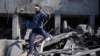 Palestinac bježi iz ruševina zgrade u Pojasu Gaze, 21. februar 2024. (AP/Adel Hana)
