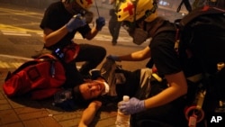 Medical workers help a protester in pain from tear gas fired by policemen on a street in Hong Kong, July 21, 2019. 