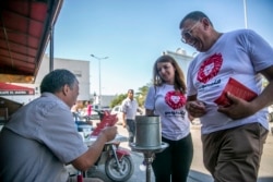 Parliamentary election candidate Yeah Loumi, right, of the Kalb Tounes (The heart of Tunisia) party, talks with man in a cafe outside Tunis, Oct.1, 2019.