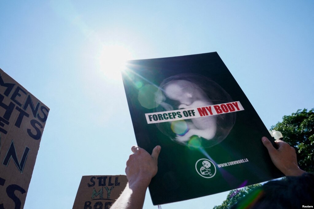 Un manifestante a favor del fallo muestra un cartel que expresa "fórceps, lejos de mi cuerpo", frente a la Corte Suprema, en Washington DC, el 25 de junio de 2022.