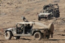 Israeli soldiers drive military vehicles during an exercise in the Israeli controlled Golan Heights near the border with Syria, Aug. 4, 2020.