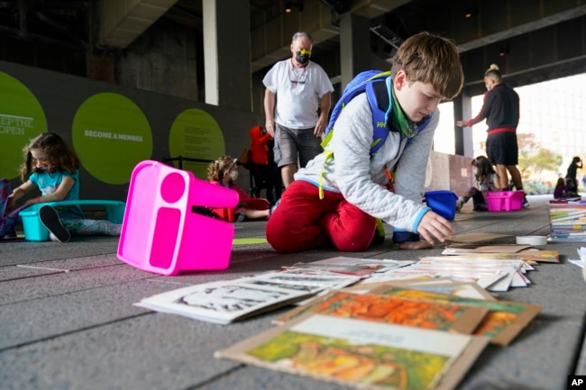 A students from Public School 11 picks out art supplies during an art class at the High Line Park Wednesday, Oct. 21, 2020, in New York. (AP Photo/Frank Franklin II)