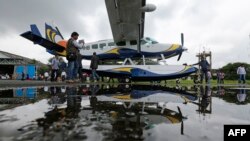 Un homme prend une photo d'un hydravion Cessna 208 Caravan 1 avant de quitter l'aérodrome de Juhu à Mumbai le 25 août 2014