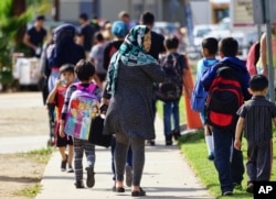 FILE - In this Oct. 5, 2016, photo, parents pick up their children at Naranca Elementary in El Cajon, California. The school is one of many in the San Diego suburb that has received an influx of Syrian refugees.