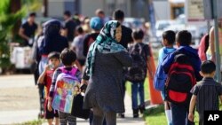 FILE - In this Oct. 5, 2016 photo, parents pick up their children at Naranca Elementary in El Cajon, Calif. The school is one of many in the San Diego suburb that has received an influx of Syrian refugees.