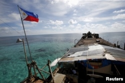 Bendera Filipina berkibar di BRP Sierra Madre, kapal tua Angkatan Laut Filipina yang terdampar sejak 1999 dan kini menjadi pangkalan militer Filipina di Second Thomas Shoal di Laut China Selatan, 29 Maret 2014. (Foto: REUTERS/Erik De Castro)