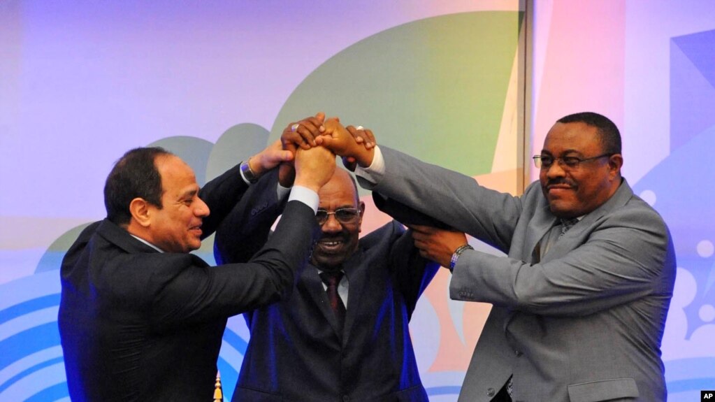 FILE - Sudanese President Omar al-Bashir, (c), Egyptian President Abdel-Fattah el-Sissi, (l), and Ethiopian Prime Minister Hailemariam Desalegn, (r), hold hands after signing an agreement on sharing water from the Nile River, in Khartoum, Sudan, March 23, 2015. 