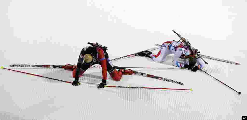 Hai vận động viên Zina Kocher của Canada (trái) và Anais Bescond của Pháp vừa hoàn thành bộ môn trượt tuyết kết hợp với bắn súng ở Krasnaya Polyana, Nga, 9/2/14