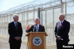 FILE - U.S. Attorney General Jeff Sessions speaks as Secretary of Homeland Security John Kelly, right, and U.S. Senator Ron Johnson look on while visiting the U.S.-Mexico border area in San Diego, California, April 21, 2017.