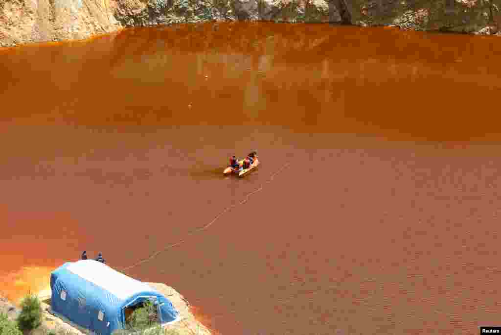 Forensics officers search Kokkinopezoula Lake, also known as "red lake," for possible bodies of victims of a suspected serial killer near the village of Mitsero, Cyprus.