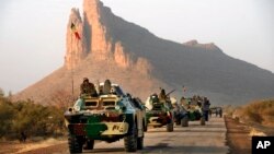 A convoy of Malian troops makes a stop to test their weapons near Hambori, northern Mali, on the road to Gao, February 4, 2013. 