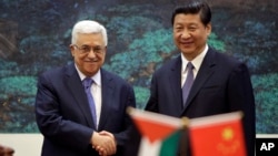 China's President Xi Jinping, right, shakes hands with his Palestinian counterpart Mahmoud Abbas during a signing ceremony at the Great Hall of the People in Beijing, China, May 6, 2013.