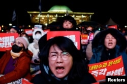 2024년 12월 7일 한국 여의도 국회 앞에서 윤석열 대통령 탄핵을 촉구하는 집회에 참석한 시위대가 구호를 외치고 있다.