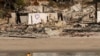 A kayaker goes past a row of homes damaged by the Palisades Fire, Jan. 15, 2025, in Malibu, Calif. 