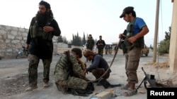 Rebel fighters are seen tending to their weapons, in Aleppo, Syria, August 6, 2016.