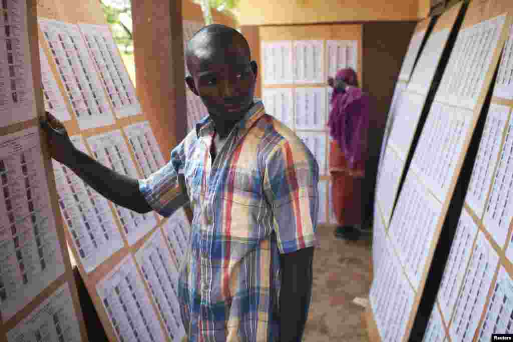A man searches for his name on a list of eligible voters at an election center in Bamako, Mali, July 23, 2013. 