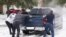 Residents help a pickup driver get out of ice on the road in Round Rock, Texas, on February 17, 2021, after a winter storm. 