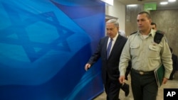 Israel's Prime Minister Benjamin Netanyahu, left, arrives for the weekly cabinet meeting in Jerusalem, Feb. 15, 2015. 