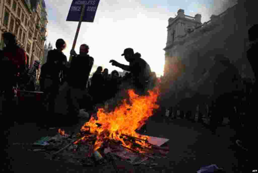 Protesters dance as they burn their placards as thousands of student protest against tuition fees at Whitehall in London, Wednesday, Nov. 24, 2010. Thousands of British students protested Wednesday against government plans to triple tuition fees, two week