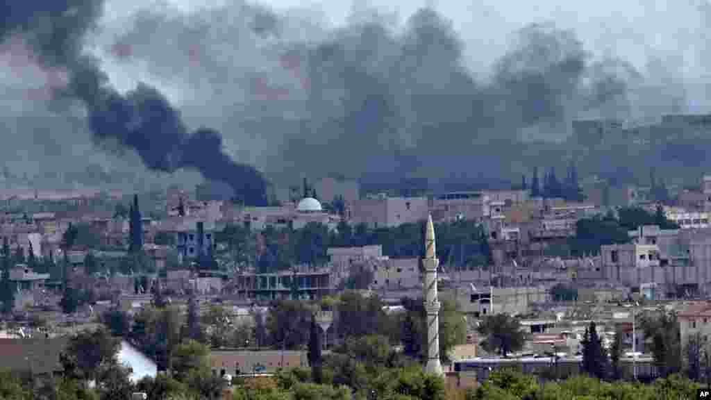 Smoke rises above the Syrian town of Kobani during fighting between Islamic State and Kurdish forces, seen from a hilltop on the outskirts of Suruc, Turkey, near the Turkey-Syria border, Oct. 26, 2014. 