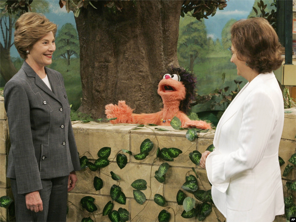 Ibu Negara AS Laura Bush (kiri) dan Suzanne Mubarak, istri Presiden Mesir Hosni Mubarak (kanan) berbincang-bincang dengan Khokha (tengah) seorang karakter dari &quot;Alam Simsim,&quot; Sesame Street versi Mesir, pada 23 Mei 2005 di Giza, Mesir.