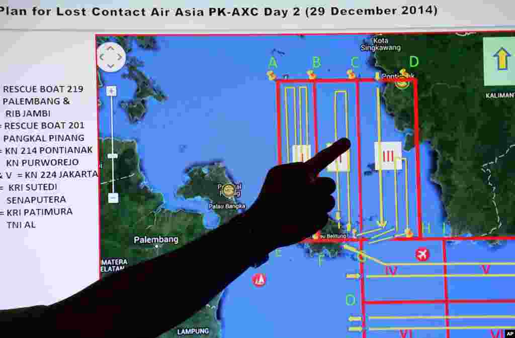 A member of the Indonesian National Search and Rescue Agency (BASARNAS) points to a map of a search area during a briefing prior to a search and rescue operation of the missing AirAsia flight 8501, at Pangkal Pinang command post in Sumatra Island, Indonesia, Dec. 29, 2014.