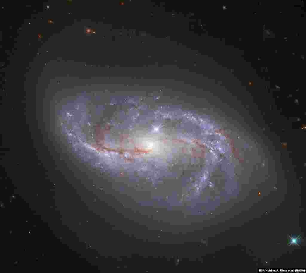 តេឡេទស្សន៍ Hubble Space Telescope របស់​អង្គការ​ណាសា/ទីភ្នាក់ងារ​អវកាស​អឺរ៉ុប​ផ្តិត​យក​រូបភាព​នៅ​ពេល​ឆ្លង​កាត់​បណ្តុំ​ពន្លឺ​មាន​រូប​ដូច​ដៃ​ជាច្រើន ដែល​វិល​ជុំវិញ​គន្លង​ផ្កាយ NGC 2608។
