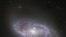 Looking deep into the Universe, the NASA/ESA Hubble Space Telescope catches a passing glimpse of the numerous arm-like structures that sweep around this barred spiral galaxy, known as NGC 2608. 
