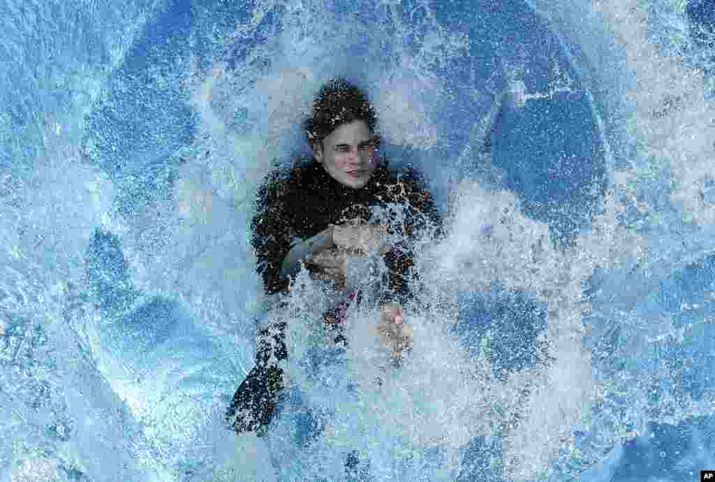 A swimmer jumps into the water during the opening day of the public open-air pool in Cologne, Germany.