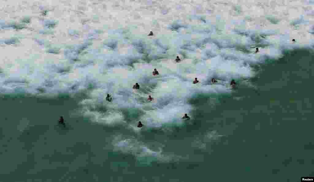 Residents and tourists swim in the sea at Barra da Tijuca beach during a summer day in Rio de Janeiro, Brazil, Jan. 15, 2017.