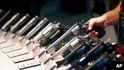 FILE - Handguns are shown at the Smith & Wesson booth at a trade show in Las Vegas, Jan. 19, 2016. Mexico has sued U.S. gun companies and distributors, arguing that their commercial practices have unleashed tremendous bloodshed in Mexico. 