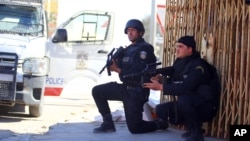 Tunisian police officers take positions as they search for attackers still at large in the outskirts of Ben Guerdane, southern Tunisia, March 8, 2016.
