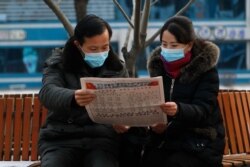지난 11일 북한 평양 미래과학자거리에서 시민들이 신문을 읽고 있다.